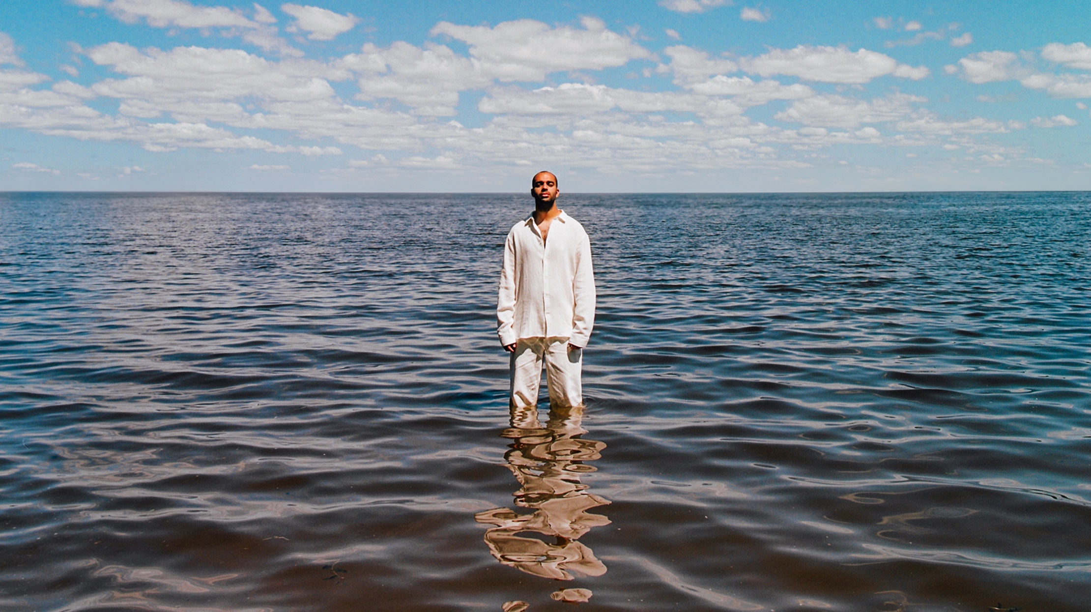 Foto des Künstlers Ash, der im Meer steht